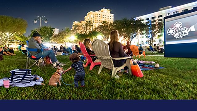 Night image of people seated on the Great Lawn watching a Screen on the Green free outdoor movie.